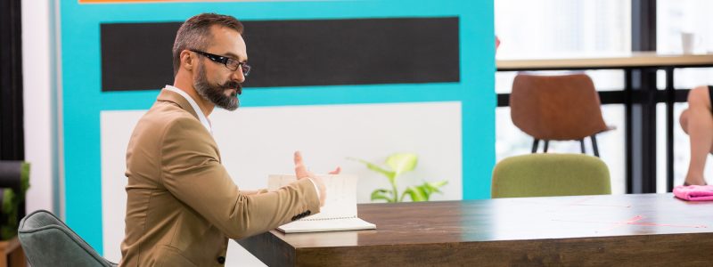 Caucasian businessman working at desk in co working space.